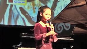 Ahe (10) plays at a concert at L'Espace in Hanoi, Vietnam. She holds a welcome speech in Vietnamese and English.